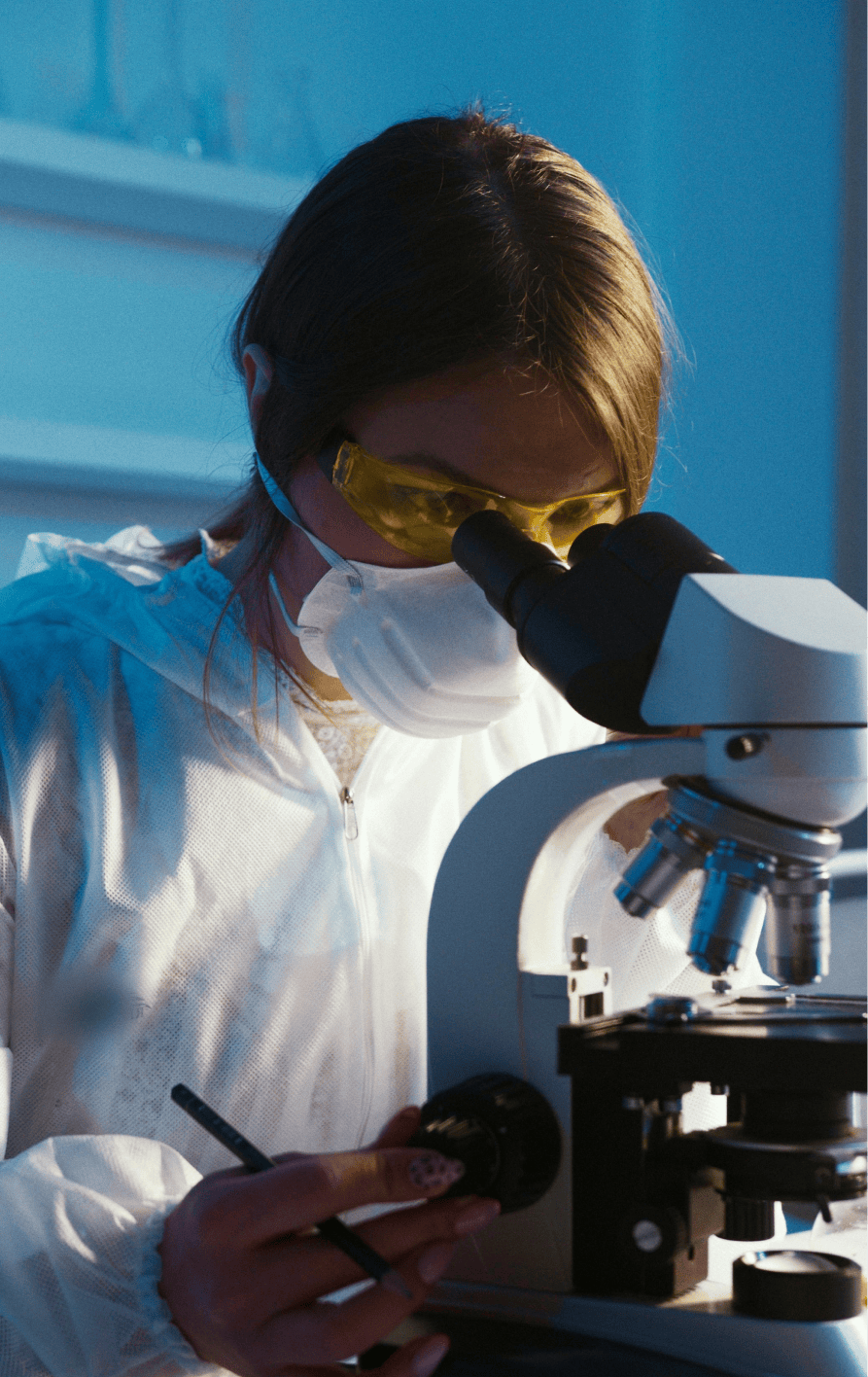 Woman looking through microscope in lab